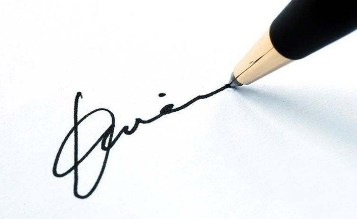 Kuglepen som underskriver et dokument med en fiktiv underskrift 